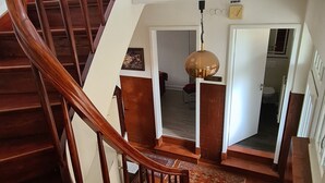 Una escalera de madera con barandilla que conduce a un piso superior.