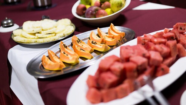 Ett bord med ett urval av olika frukter och snacks.