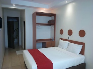 A hotel room with a bed, a wardrobe, and a mirror. - Daiichi Hotels (Isiolo)