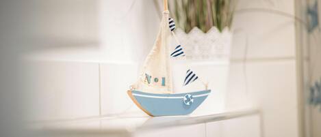 A small sailboat with the word "NO1" on it, placed on a white surface.