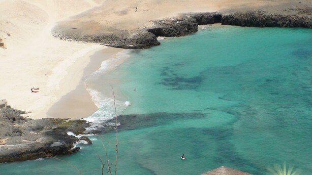An aerial view of a beach with clear turquoise waters, sandy shore, and rocky outcrops. - Boa Vista Holidays (Boa Vista)