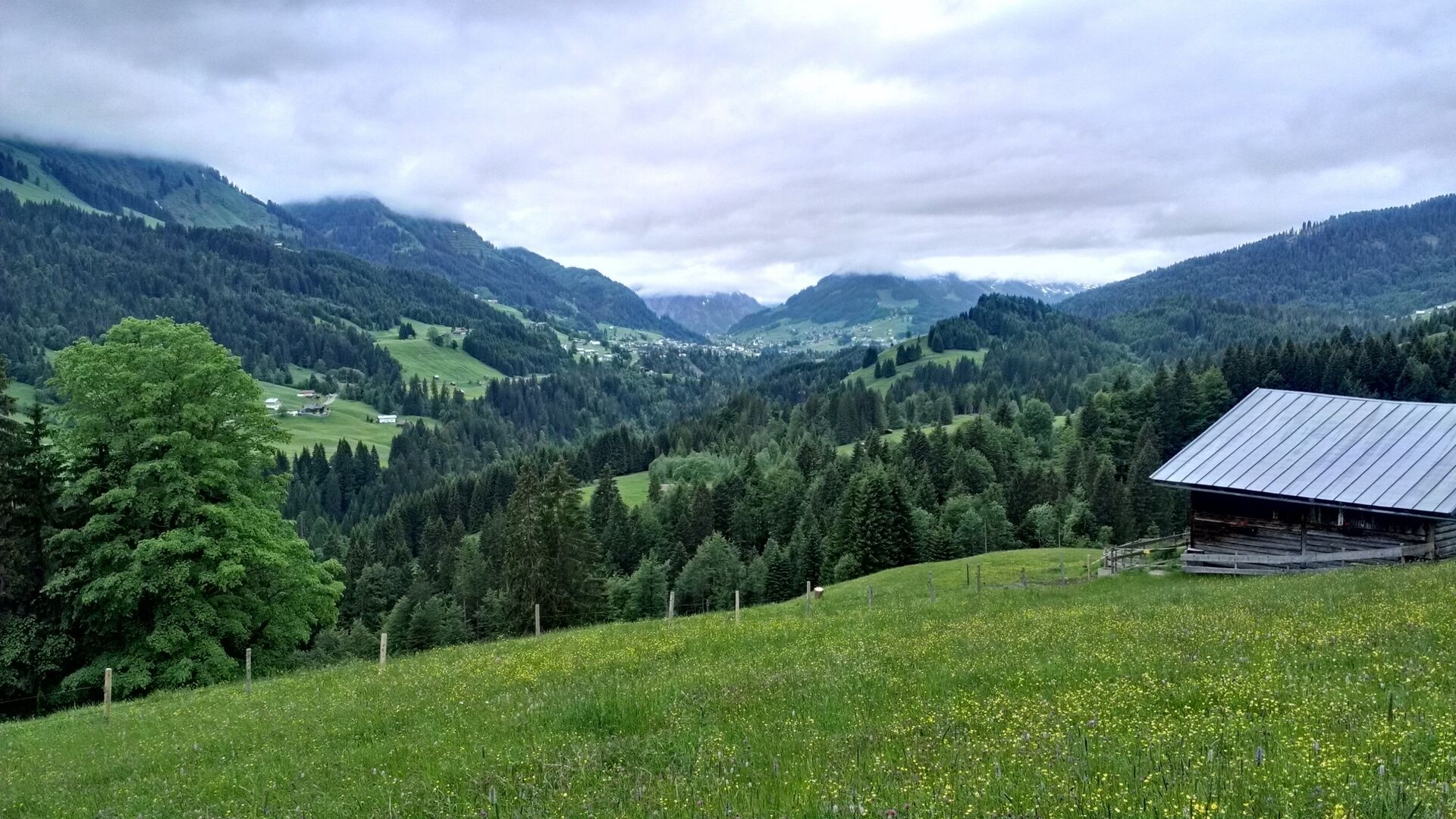 Paisagem montanhosa com uma cabana de madeira.