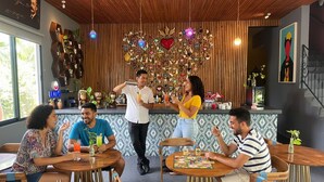 A cozy restaurant with wooden furniture, a decorative wall hanging, and a bar area. - Casa Chukum Bacalar (Bacalar)
