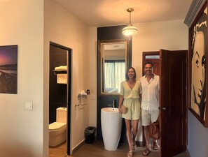 A modern bathroom with a toilet, sink, and mirror.