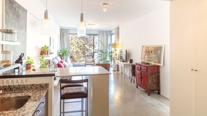 Eine moderne Küche mit Granitwerkplatten, einer Bar und einem Essbereich mit einer Couch und Sesseln.
