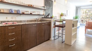 Eine moderne Küche mit dunklen Holzschränken, einer Granit-Arbeitsplatte und einer Theke mit Barhocker.