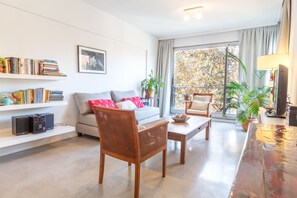 Apartamento superior, 1 cama Queen e sofá-cama, para não fumantes, vista para a cidade | Área de estar | TV de tela plana