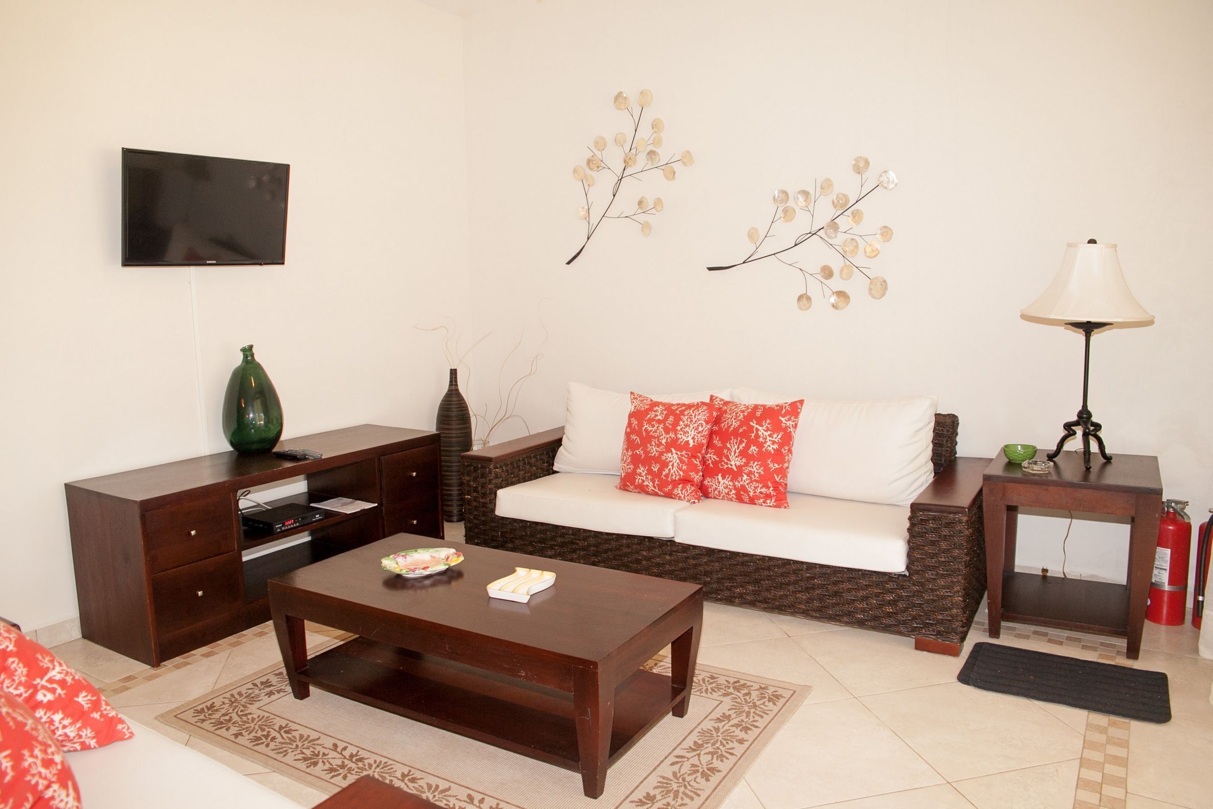 A living room with a sofa, coffee table, TV, and decorative wall art.