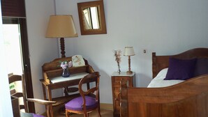 Un dormitorio con una cama de madera, un escritorio, una silla y dos mesitas de noche con lámparas.