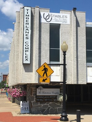 Un bâtiment portant les enseignes « Timberlands Complex » et « The Stables Inn Suites », avec un panneau indiquant un passage piéton.