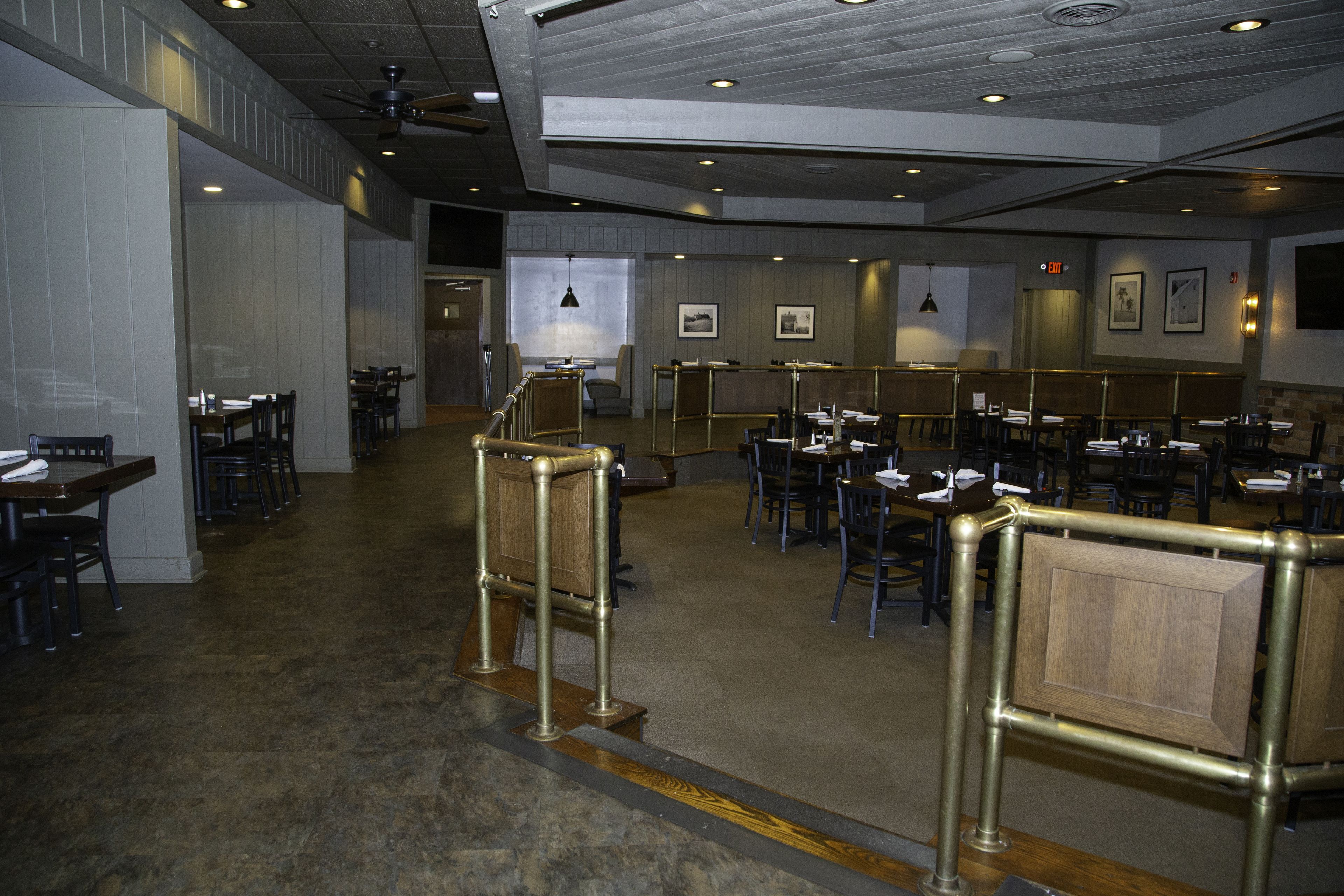 A spacious restaurant with high ceilings, recessed lighting, and a modern industrial design.