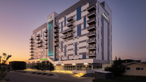 A multi-story hotel with a modern design, featuring balconies on each floor and a prominent entrance with signage. - Pomeroy Hotel Fort McMurray (Fort McMurray)