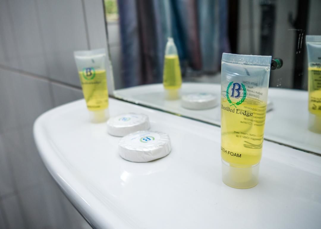 A bathroom sink with three tubes of Bested Lodge soap and two soap bars.