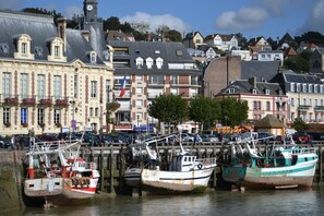 A harbor with boats docked, a building with a clock tower, and a flag. - MEZZANINE Studio in DOWNTOWN (casino & beach <150m); NOT suitable for everyone. (Trouville-Sur-Mer)