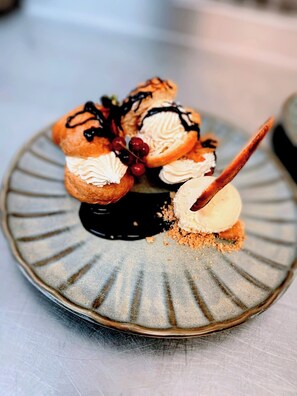 A dessert plate with éclairs, cherries, and ice cream. - The Mill House Hotel (Buckie)