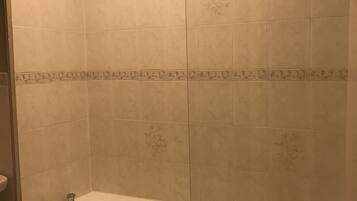 A bathroom with a bathtub, a shower, and a toilet.