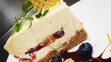 Una rebanada de pastel de queso con fresas, arándanos y costra enrejada sobre un plato blanco.