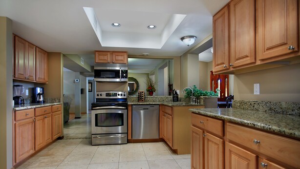 A modern kitchen with wooden cabinets, stainless steel appliances, and a skylight. - Fairview (Scottsdale)