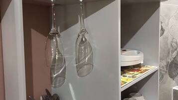Eine Küche mit einem weißen Schrank, einer Weinregalanlage und einer Kaffeemaschine.