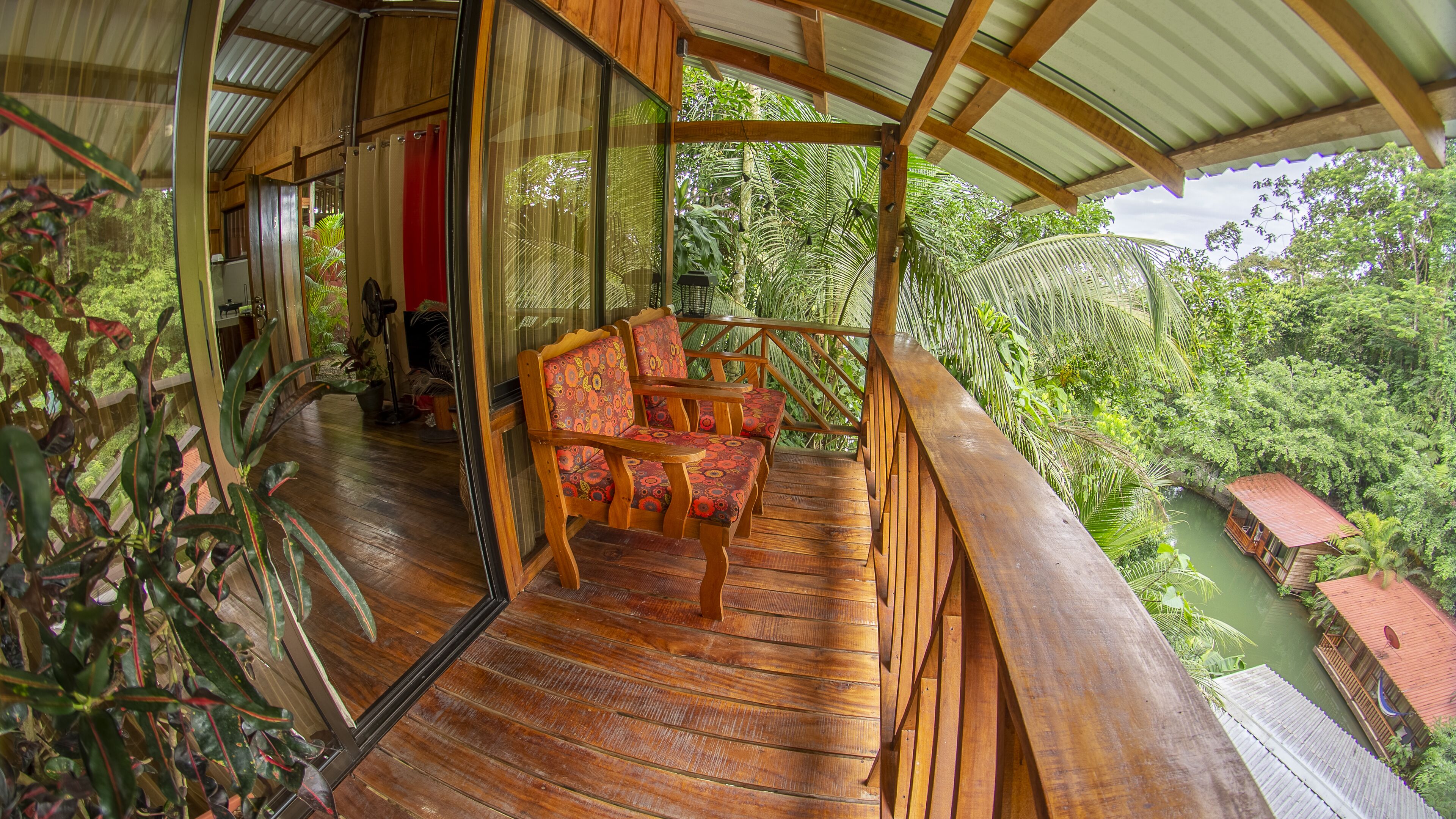 A wooden deck with a curved railing overlooking a lush green landscape.