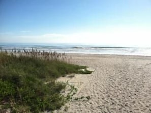 Na praia, espreguiçadeiras, toalhas de praia 