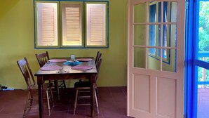 A dining area with a table, chairs, and a window with blinds. - Just in-November dates have just become available  (L’Esterre)