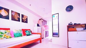 A modern hotel room with a bed, a wardrobe, a mirror, and wall art.