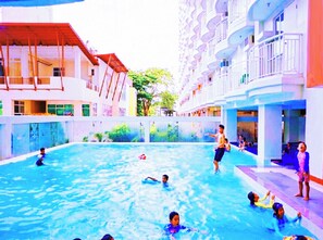 An indoor swimming pool with multiple levels of balconies and a poolside area.