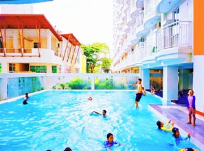 Une piscine intérieure entourée d’immeubles à plusieurs étages dotés de balcons.