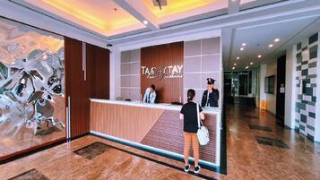 A reception desk with a modern design, a large abstract artwork on the wall, and a check-in counter.