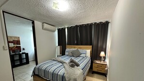 Une chambre à coucher avec un lit, une table de chevet et une commode.