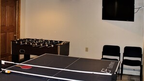 A ping pong table with a net, a foosball table, and two chairs. - Cooperstown Baseball Rentals - Elm-Triple Play #2L (Oneonta)
