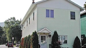 Et toetagers hus med en veranda, en lille forhave og en indkørsel.