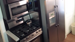 Eine kleine Küche mit integriertem Mikrowellenherd, Backofen und Kühlschrank.