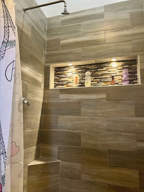 Un espace douche avec des carreaux de bois et une étagère contenant des articles de toilette.