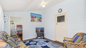 A cozy room with a bed, a TV, and a door.