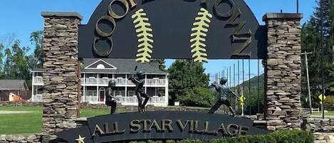 A sign for Cooperstown with baseball imagery and the text 'All Star Village.'