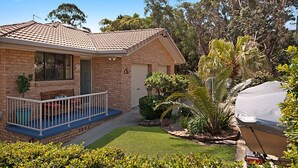 A residential house with a brick exterior, a front porch, and a small garden with various plants. - 2/36 Sunderland Street, Evans Head (Evans Head)