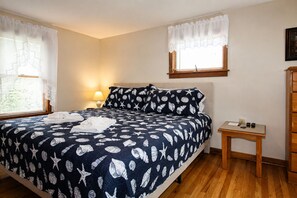 A bedroom with a bed, bedside table, and a nightstand. - Cooperstown Baseball Rentals - Columbia House (Oneonta)