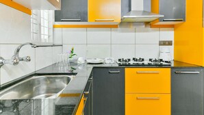 Una cocina moderna con un lavamanos de acero inoxidable, una estufa a gas y una cafetera.