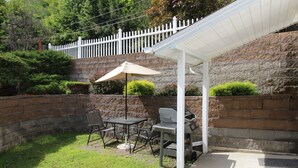 A patio with a grill, table, chairs, and an umbrella. - Cooperstown Baseball Rentals - 1st Baseman (Oneonta)