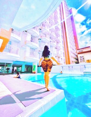 Un hôtel doté d’une piscine, de plusieurs balcons et offrant une vue sur le ciel.