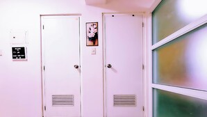 Two white doors with vents, a welcome sign, and a floral painting. - BestLove HideAway 1-BR *Parking, Pool (Tagaytay)