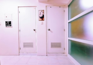 Two white doors with vents, a welcome sign, and a floral painting. - BestLove HideAway 1-BR *Parking, Pool (Tagaytay)