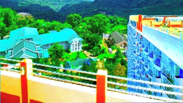 A hotel with a modern design, featuring a large building with balconies and a view of the surrounding landscape. - BestLove HideAway 1-BR *Parking, Pool (Tagaytay)