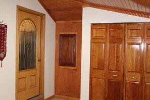 Une porte en bois avec un panneau de verre, une porte simple, et un ensemble d’armoires en bois.