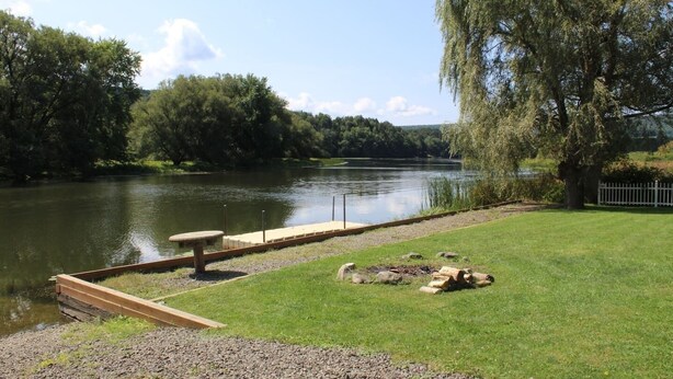 A riverside park with a wooden dock, picnic table, and benches. - Cooperstown Baseball Rentals - Goose Bay (Portlandville)
