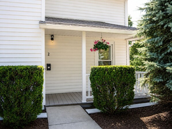 A white house with a porch, a mailbox, and a small window with a hanging flower basket. - Cooperstown Baseball Rentals - 2nd Baseman (Oneonta)