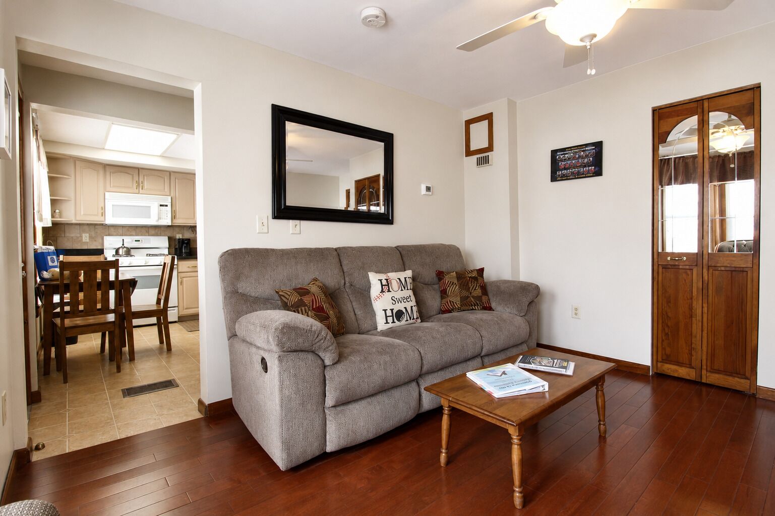 A living room with a grey sofa, wooden coffee table, and a wooden door.