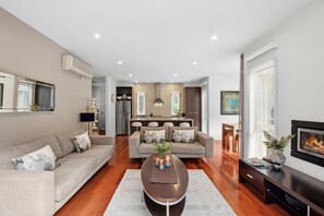 A modern living room with a sofa, coffee table, and a fireplace.